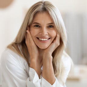 Blonde Frau im mittleren Alter strahlt mit einem Lächeln ihre innere Schönheit aus. NOBUSAN-Nutrition - Generation 55+